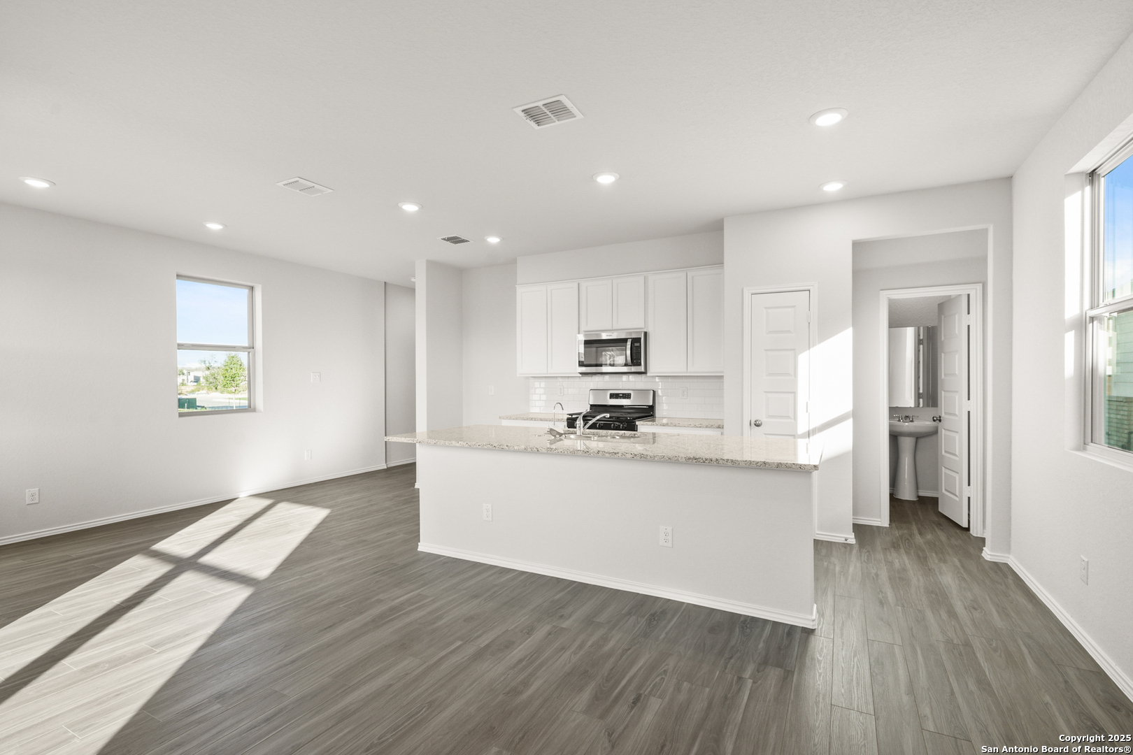 4951 Blue Ranch San Antonio, TX 78222 - Photo 6 of 24 a kitchen with stainless steel appliances a refrigerator sink and wooden floor