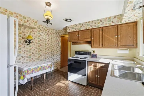 a kitchen with stainless steel appliances a stove a sink and a refrigerator