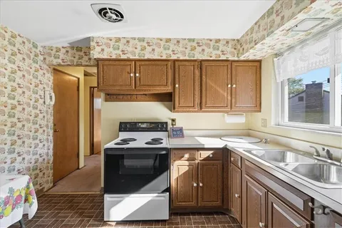 a kitchen with granite countertop a sink stove and refrigerator