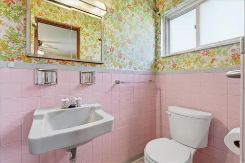 a bathroom with a toilet sink and mirror