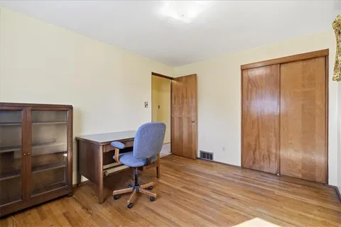 a view of a workspace with furniture and wooden floor