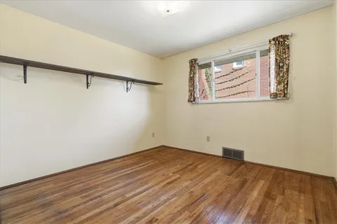 a view of a room with wooden floor and cabinet