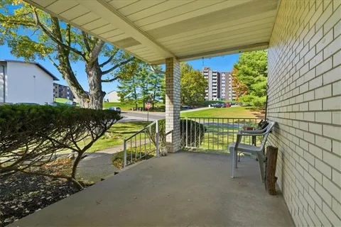 a view of a patio with table and chairs and a barbeque
