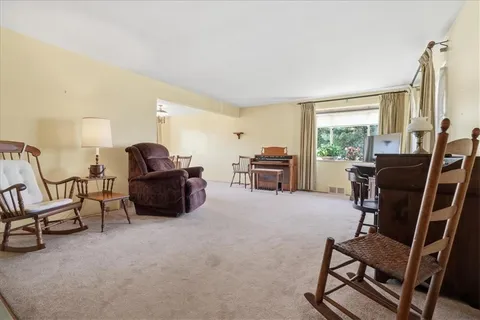 a living room with furniture a piano and a flat screen tv