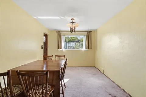 a view of a dining room with furniture wooden floor and a chandelier