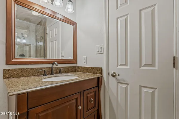 a bathroom with a granite countertop sink and a mirror