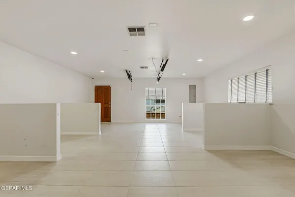 a view of a big room with kitchen and windows