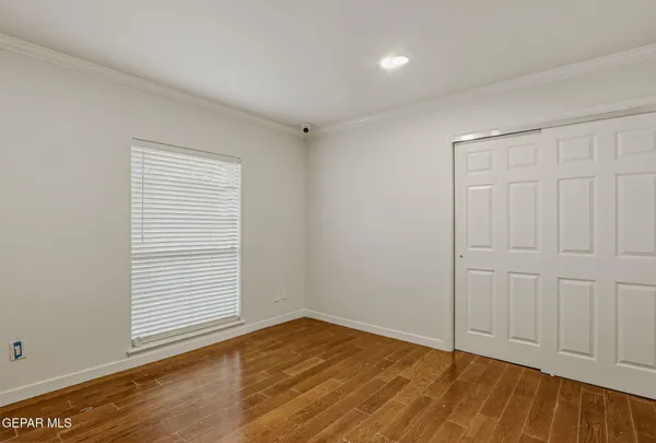 a view of a room with a flat screen tv and wooden floor