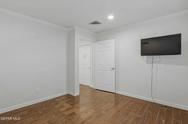 a view of an empty room with a window and wooden floor