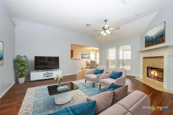 a living room with furniture a fireplace and a flat screen tv