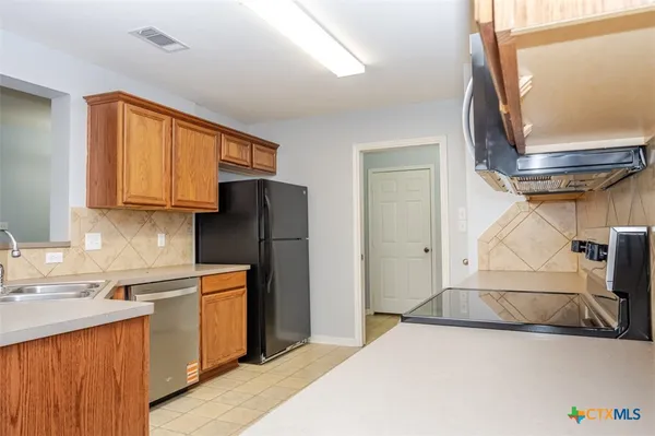 a kitchen with a refrigerator a sink and cabinets