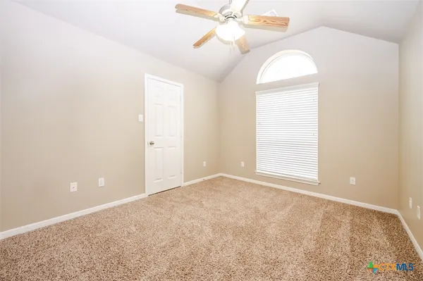 an empty room with a chandelier fan