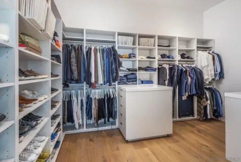 a view of walk in closet with clothes and shoes