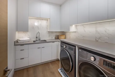 a utility room with sink dryer and washer