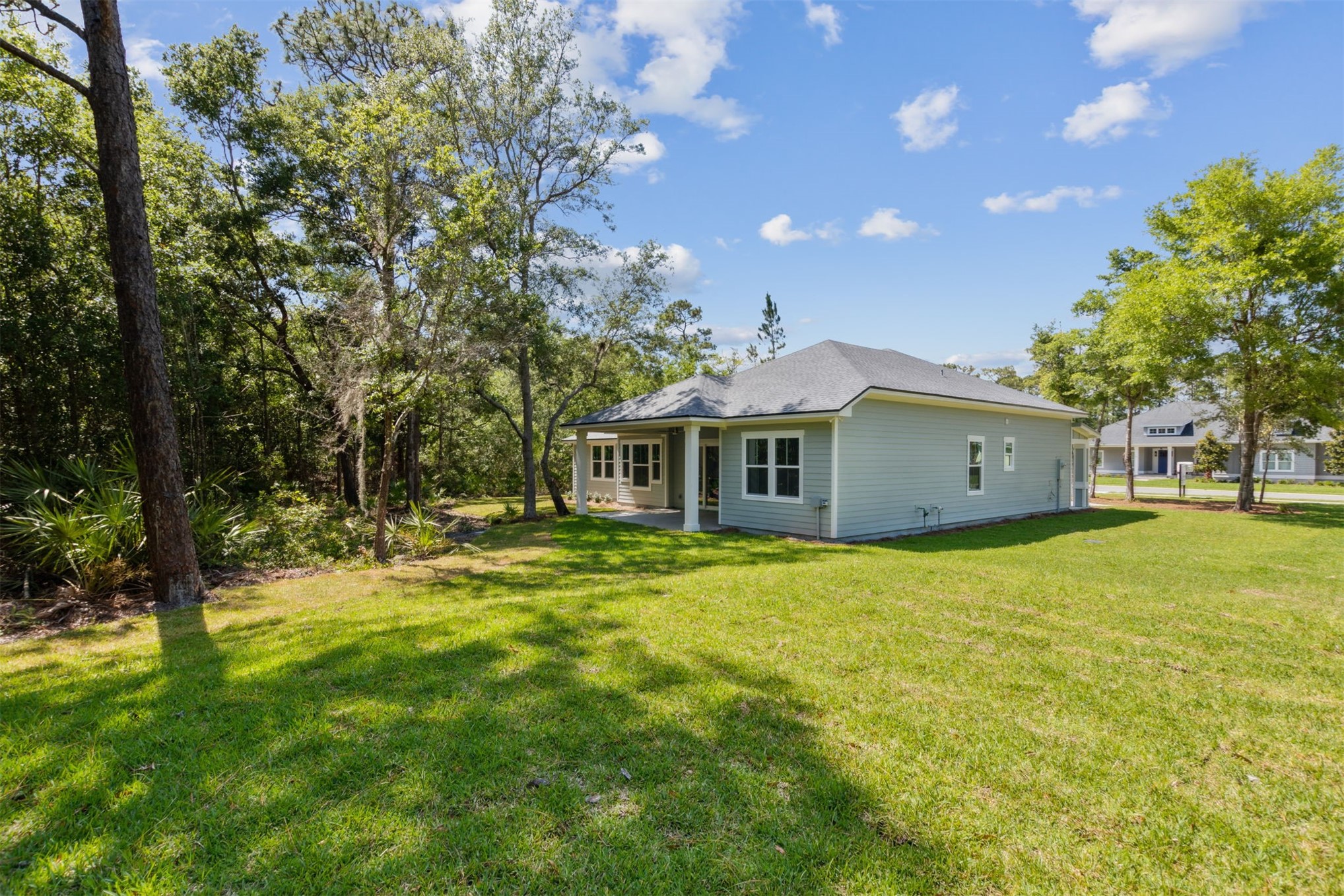 96050 Captains Pointe Road Yulee, FL 32097 - Photo 35 of 36 a yellow house sitting in middle of the green field