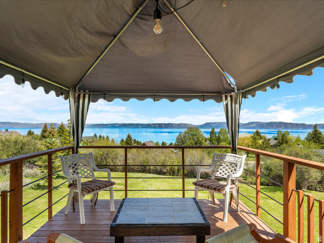 371 Lewis Loop, Unit 29 Fish Haven, ID 83287 - Photo 4 of 40 Wood-finish deck with a pergola-style canopy, offering expansive water scenery and distant mountains