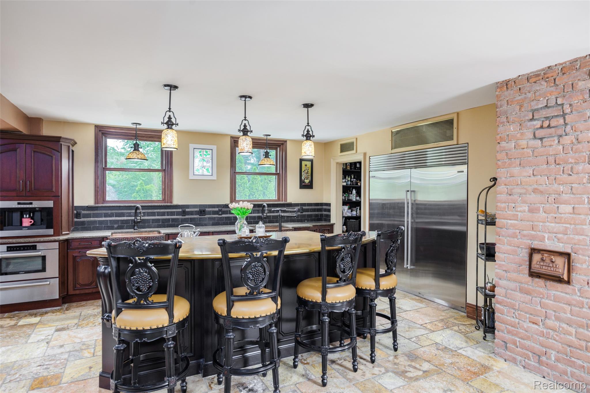 189 Cloverly Road Grosse Pointe, MI 48236 - Photo 21 of 93 Where everyone gathers. Centered around a generous gathering island, the kitchen was thoughtfully designed for the way people live and entertain today. Rich custom cabinetry, handcrafted details, and carefully chosen materials complement the home’s historic character, creating a welcoming space where family and friends naturally come together.
