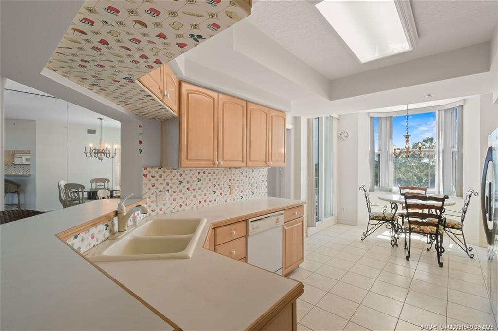 8650 South Ocean Drive, Unit 306 Jensen Beach, FL 34957 - Photo 12 of 51 a kitchen with a table chairs and a refrigerator