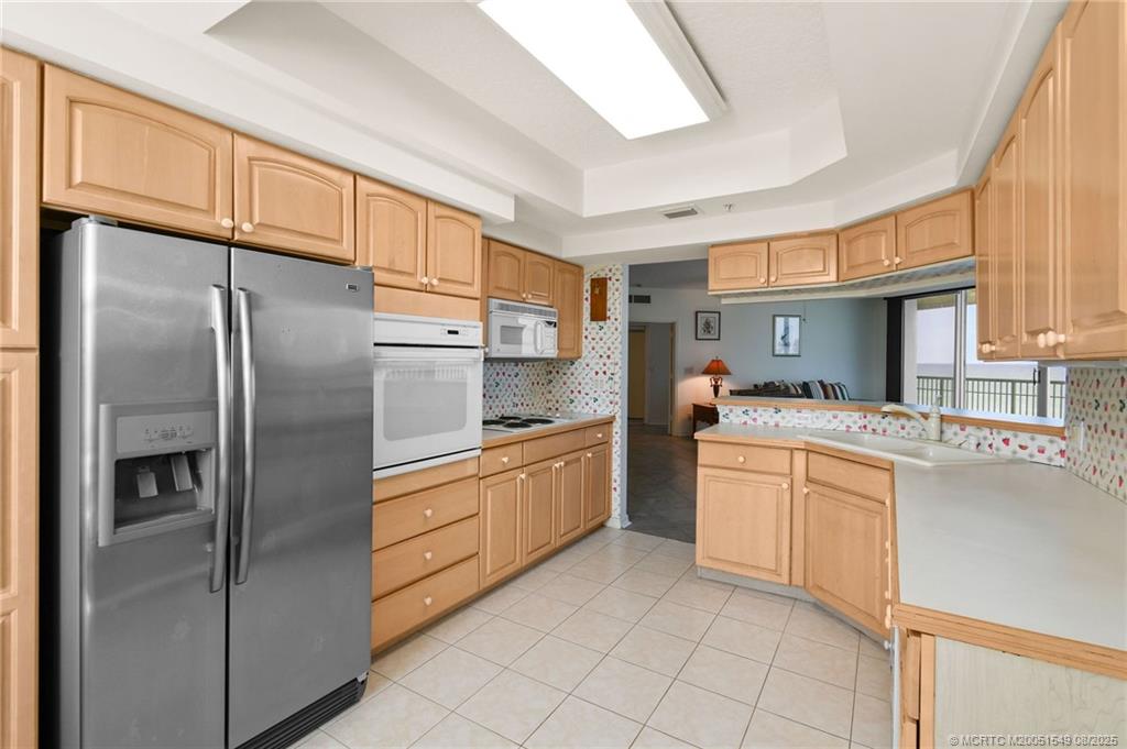 8650 South Ocean Drive, Unit 306 Jensen Beach, FL 34957 - Photo 15 of 51 a kitchen with stainless steel appliances granite countertop a refrigerator a sink dishwasher a stove with white cabinets