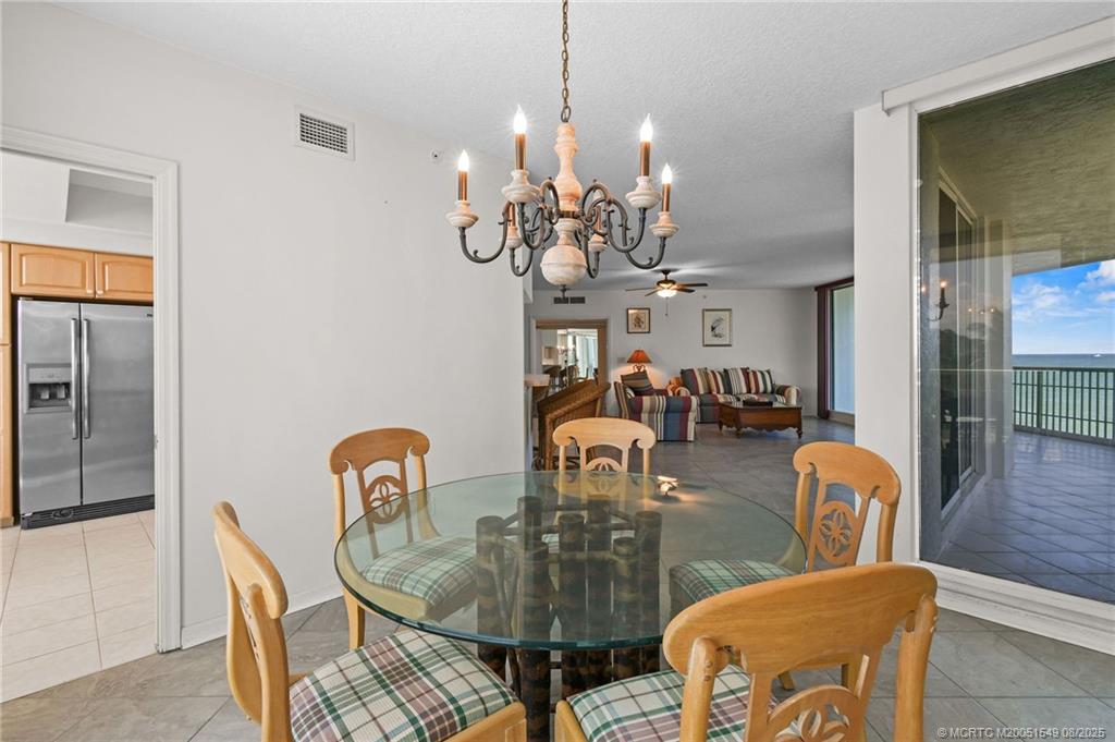 8650 South Ocean Drive, Unit 306 Jensen Beach, FL 34957 - Photo 19 of 51 a view of a dining room with furniture and chandelier