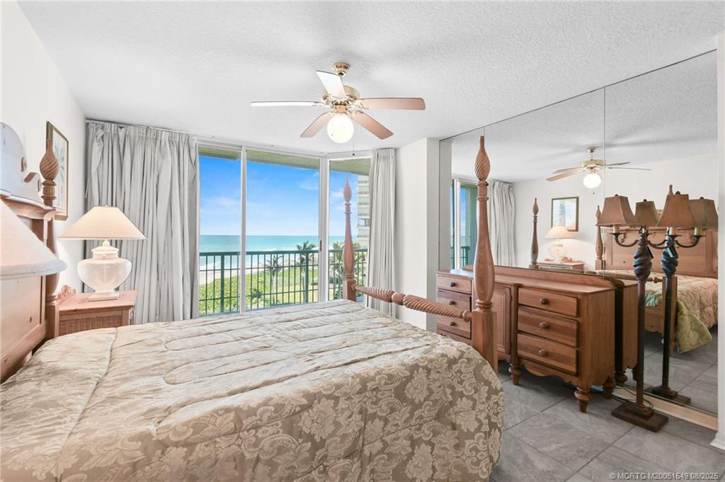 8650 South Ocean Drive, Unit 306 Jensen Beach, FL 34957 - Photo 23 of 51 a bedroom with a large bed and a chandelier