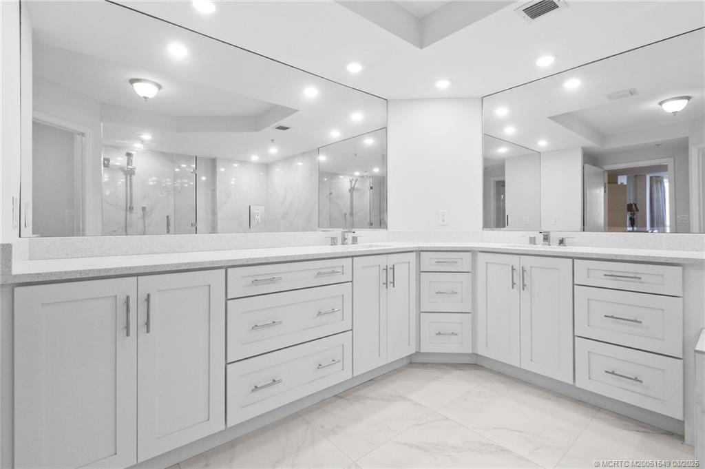 8650 South Ocean Drive, Unit 306 Jensen Beach, FL 34957 - Photo 27 of 51 a bathroom with a double vanity sink and a mirror