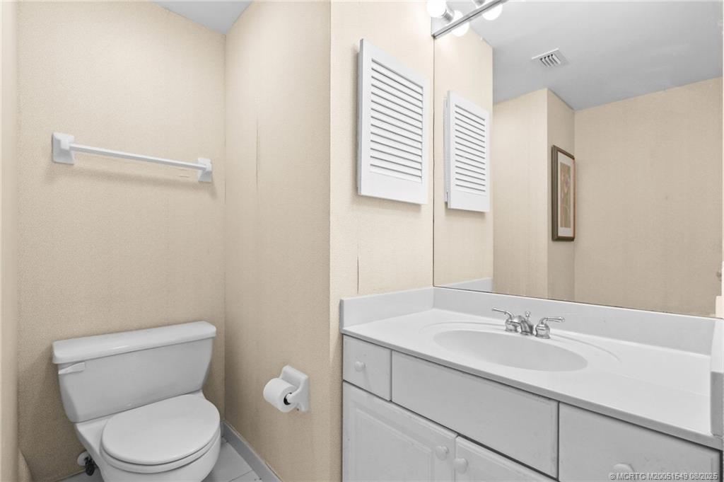 8650 South Ocean Drive, Unit 306 Jensen Beach, FL 34957 - Photo 37 of 51 a bathroom with a toilet a sink and mirror
