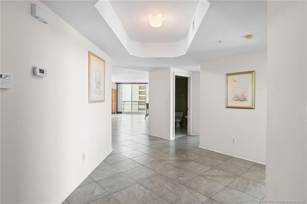 8650 South Ocean Drive, Unit 306 Jensen Beach, FL 34957 - Photo 4 of 51 a view of a hallway with wooden floor and a living room