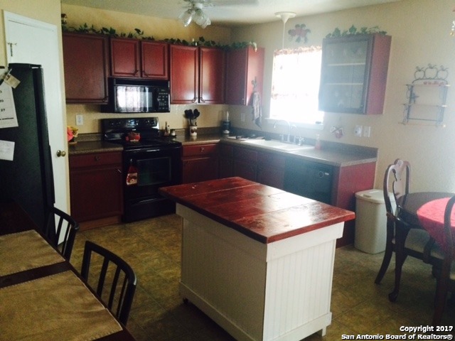 a kitchen with stainless steel appliances kitchen island granite countertop a sink a stove and a refrigerator