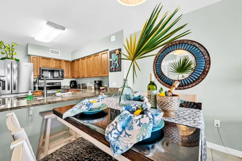 a kitchen with stainless steel appliances granite countertop a stove and a dining table