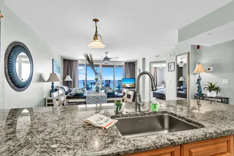 a kitchen with a stove a sink and a dining table with granite countertop