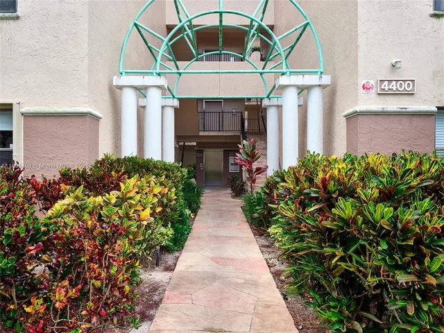 a front view of a house with a yard and fountain
