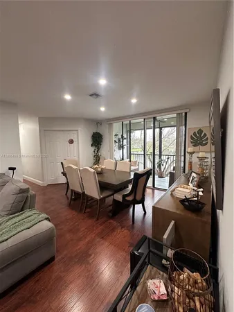 a living room with furniture wooden floor and a floor to ceiling window