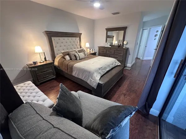 a bed sitting in a bedroom next to a window with lamp