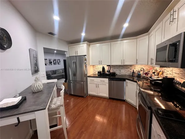 a kitchen with granite countertop stainless steel appliances and wooden cabinets