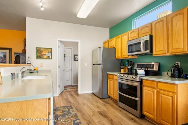 a kitchen with stainless steel appliances granite countertop a stove a sink and a refrigerator