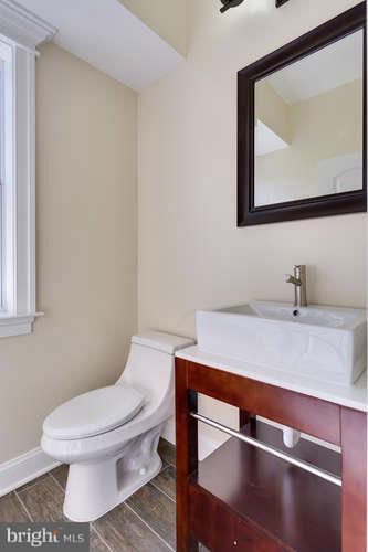 9423 Old Courthouse Road Vienna, VA 22182 - Photo 19 of 30 a bathroom with a toilet a sink and mirror