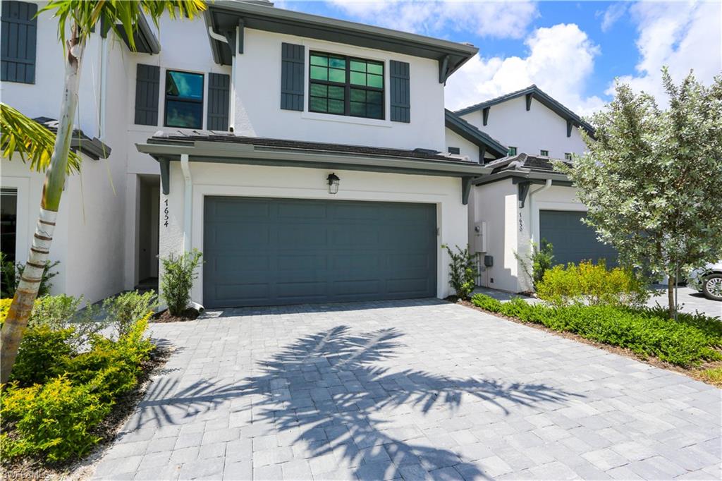 a front view of a house with a yard and a garage