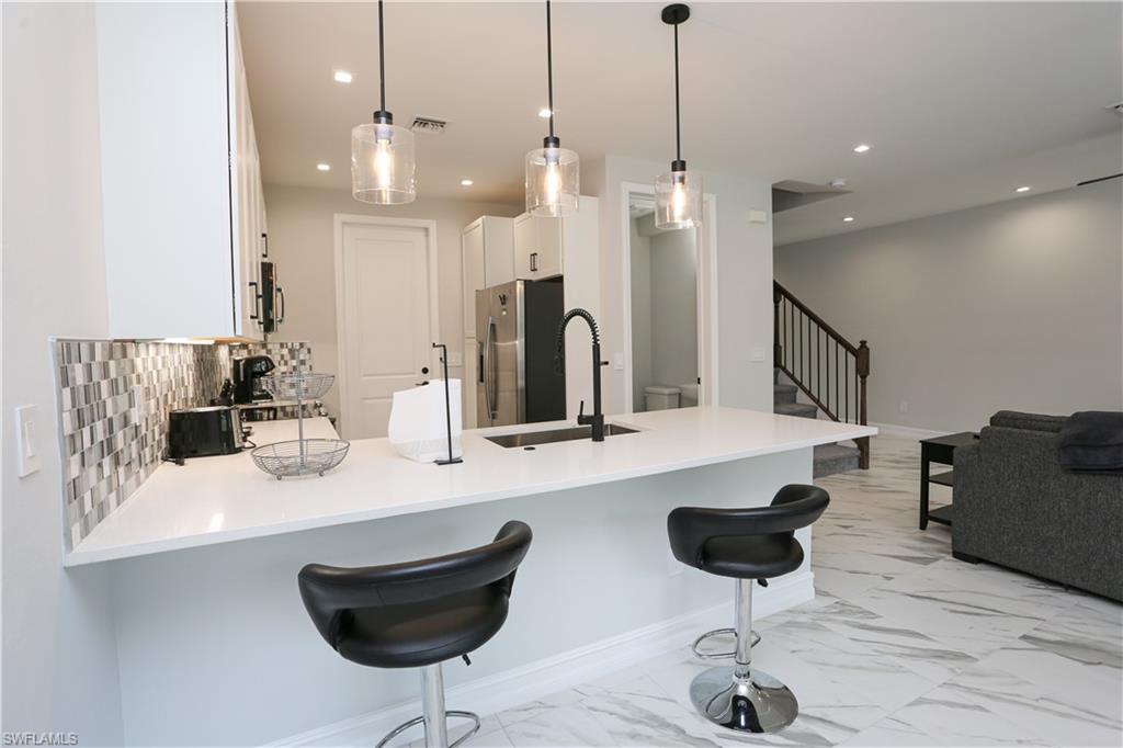 7654 Rockefeller Drive Naples, FL 34119 - Photo 11 of 35 a room with lots of chairs and mirrors