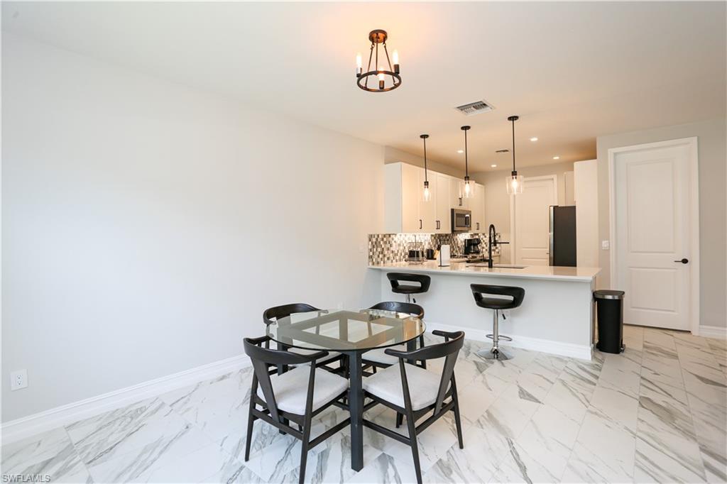 7654 Rockefeller Drive Naples, FL 34119 - Photo 14 of 35 a view of a dining room with furniture and wooden floor