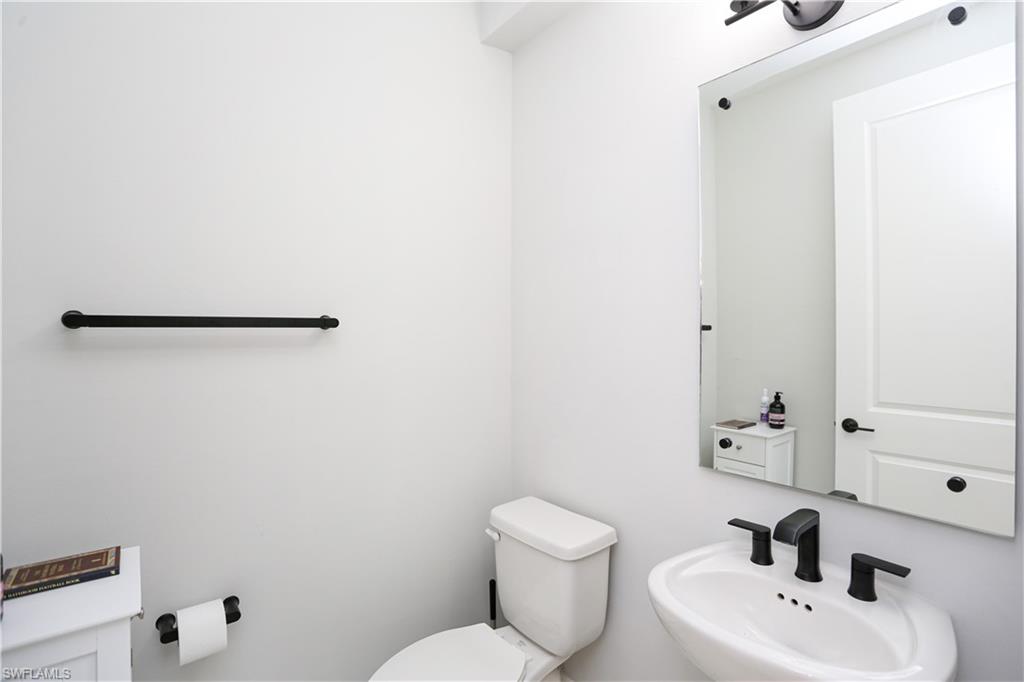 7654 Rockefeller Drive Naples, FL 34119 - Photo 19 of 35 a bathroom with a toilet sink and mirror