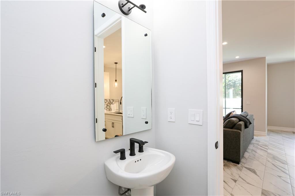 7654 Rockefeller Drive Naples, FL 34119 - Photo 20 of 35 a bathroom with a sink and a mirror