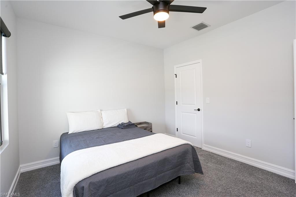 7654 Rockefeller Drive Naples, FL 34119 - Photo 27 of 35 a bedroom with a bed and a ceiling fan