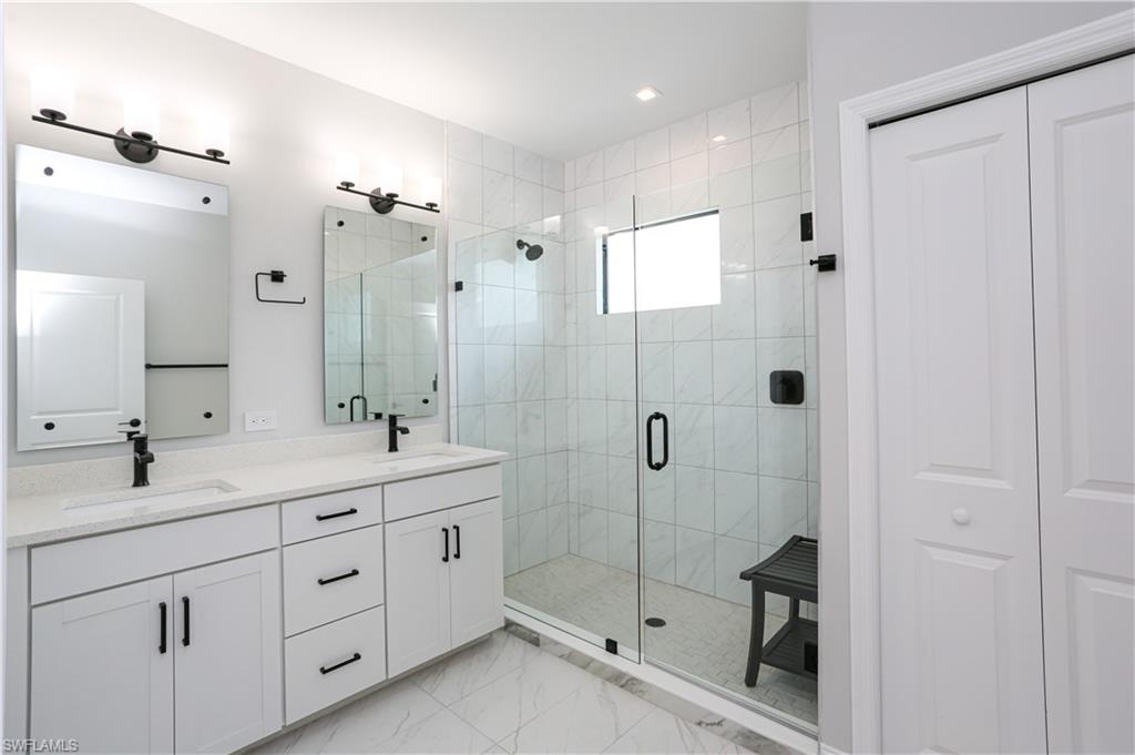 7654 Rockefeller Drive Naples, FL 34119 - Photo 34 of 35 a bathroom with double sink and a shower