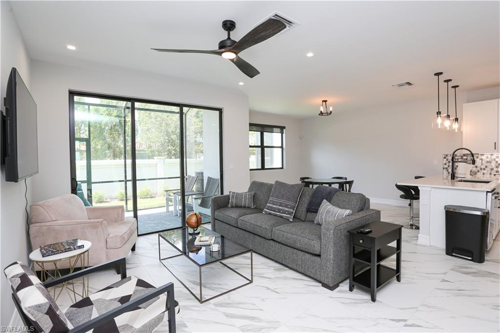 7654 Rockefeller Drive Naples, FL 34119 - Photo 7 of 35 a living room with furniture and a fireplace