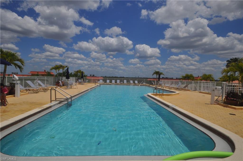 401 Bayfront Place, Unit 3201 Naples, FL 34102 - Photo 23 of 24 a view of a swimming pool with a bench and trees in the background