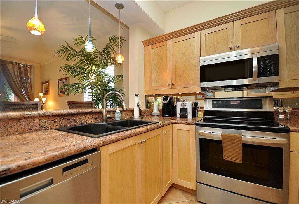 401 Bayfront Place, Unit 3201 Naples, FL 34102 - Photo 5 of 24 a kitchen with stainless steel appliances granite countertop a sink stove and microwave