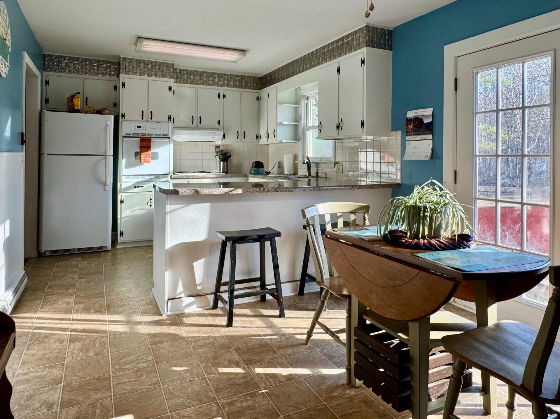 8127 Briery Branch Road Dayton, VA 22821 - Photo 6 of 23 a kitchen with stainless steel appliances granite countertop a table chairs and a refrigerator