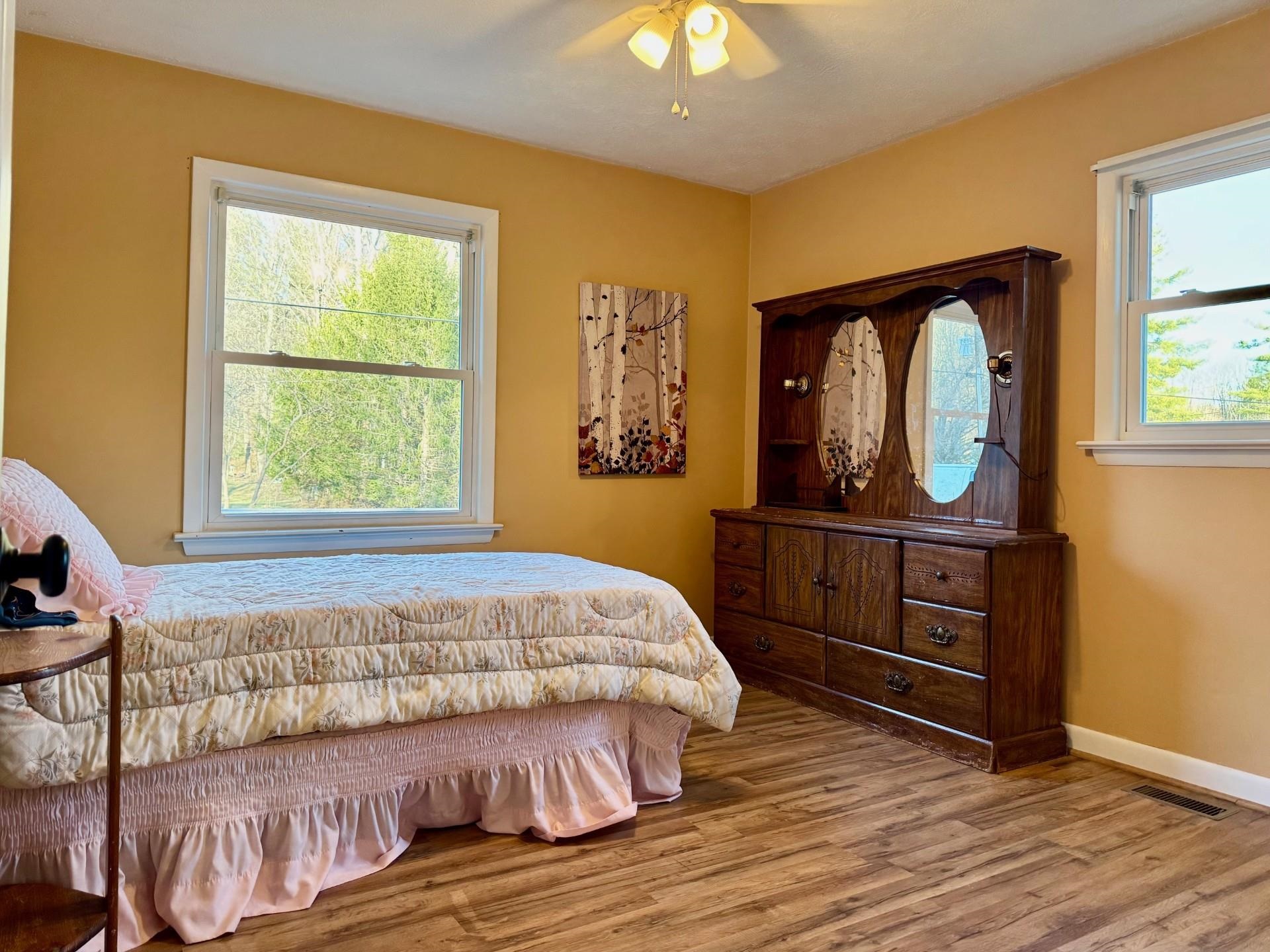 8127 Briery Branch Road Dayton, VA 22821 - Photo 9 of 23 a bedroom with a bed and a dresser with wooden floor
