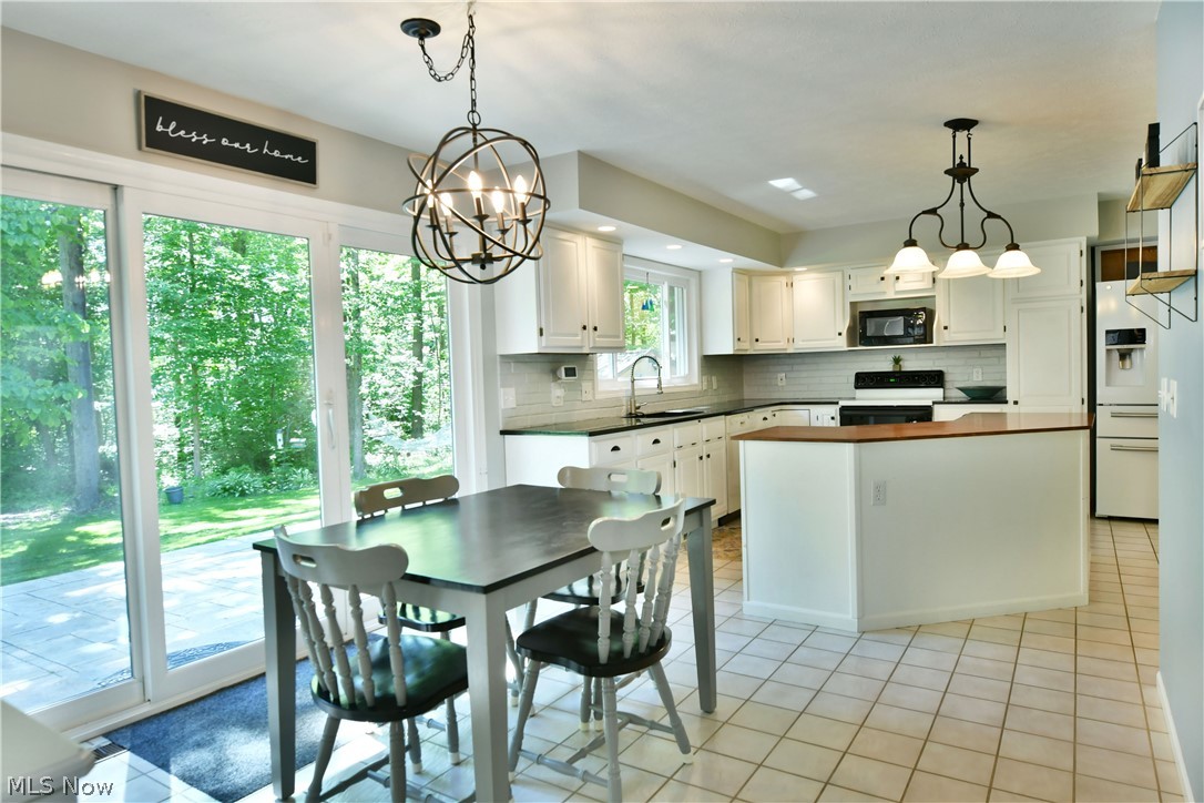 13491 Woodin Road Chardon, OH 44024 - Photo 19 of 35 Dining room featuring an inviting chandelier, sink, and light tile flooring